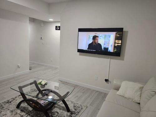 ein Wohnzimmer mit einem Sofa und einem TV an der Wand in der Unterkunft New built house, Stay in Style Guest Suite, 2bedroom, 2bed, 2bath in Edmonton
