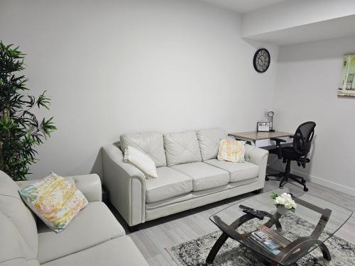 sala de estar con sofá blanco y mesa en New built house, Stay in Style Guest Suite, 2bedroom, 2bed, 2bath en Edmonton