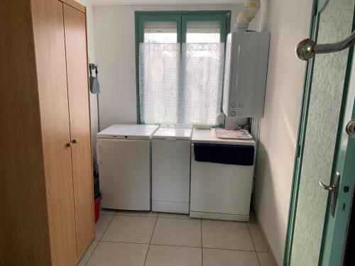 a small kitchen with a stove and a window at Maison Familiale au Calme Proche Baie d'Authie - 2 Chambres, Jardin, Stationnement - FR-1-482-137 in Fort-Mahon-Plage