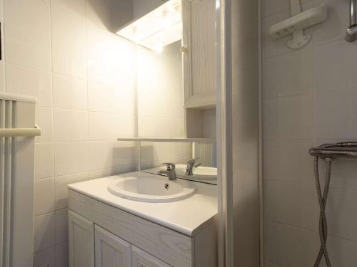 ein weißes Badezimmer mit einem Waschbecken und einem Spiegel in der Unterkunft Appartement Cauterets, 2 pièces, 4 personnes - FR-1-401-286 in Cauterets
