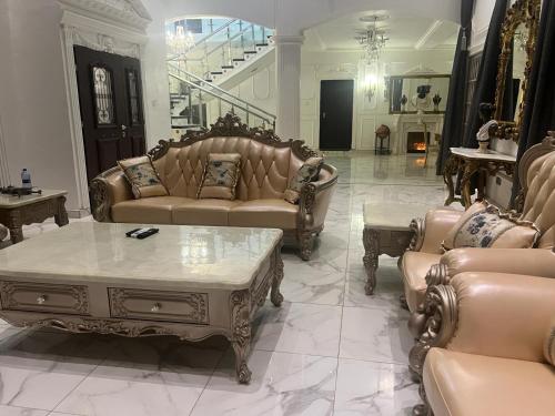 a living room with couches and a coffee table at The Peacock Mansion in Kumasi