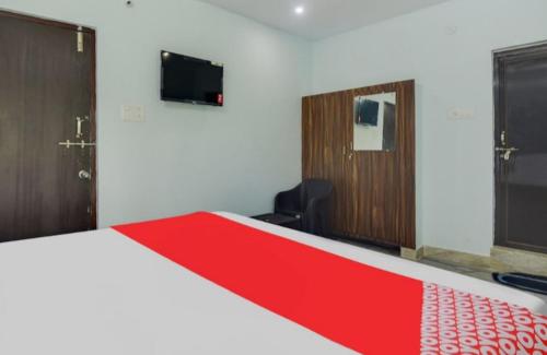 a bedroom with a red and white bed and a tv at The pearl guest house in Visakhapatnam