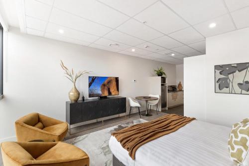 a bedroom with a bed and a table and chairs at 12th Avenue Suites in Queenstown