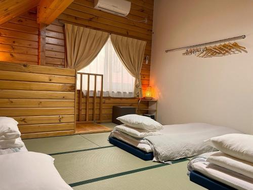 a bedroom with two beds and a window at Log Cottage Epoch in Hakuba