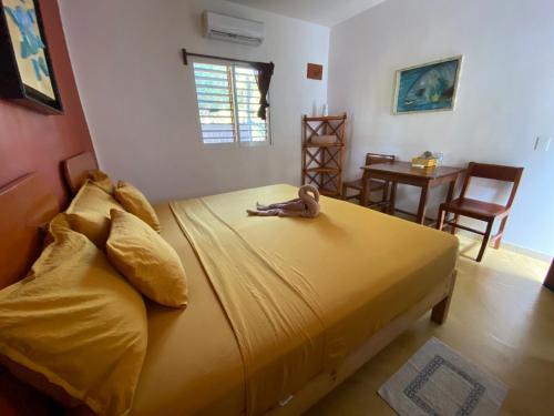a bedroom with a large yellow bed with a stuffed animal on it at Casa Pascale in Punta Allen