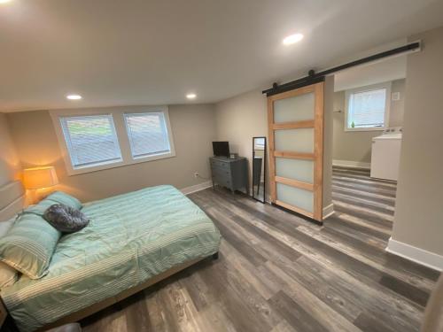 a bedroom with a bed and a wooden floor at Newly Renovated Lincolnton Downtown Rail Trail Apartment - Walk to Main St in Lincolnton