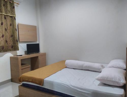 niewielka sypialnia z łóżkiem i telewizorem w obiekcie GRHA RAF HOMESTAY w mieście Makale