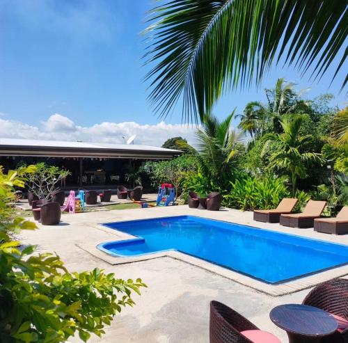 uma piscina num resort com cadeiras e palmeiras em Nadi Fancy Hotel em Nadi
