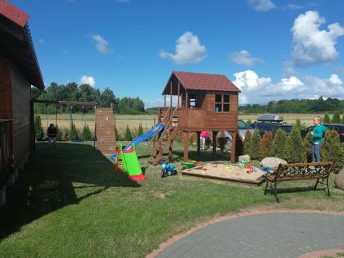 a playground with a tree house and a slide at Ferienhaus in Rusinowo mit Großer Terrasse - b54244 in Rusinowo