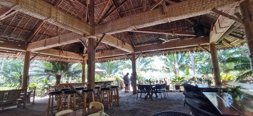 ein Restaurant mit Tischen und Stühlen und Menschen im Hintergrund in der Unterkunft Sulu Sunset Beach Resort in Nauhang