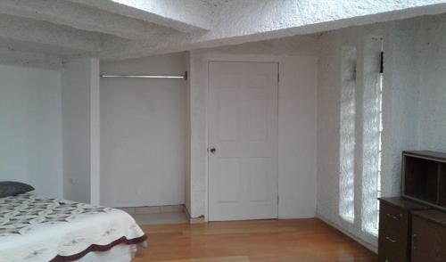 a bedroom with a bed and a white door at Agradable hogar en Playas de Tijuana in Tijuana