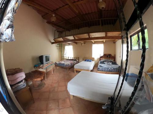 にある¡Casa rústica con cabaña! Montaña, río, niebla, sol!のベッド2台、テレビが備わる広い客室です。