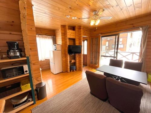 a dining room with a table and chairs at Log Cottage Epoch in Hakuba