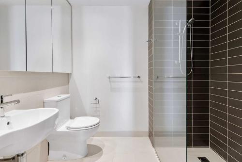 a bathroom with a toilet and a sink and a shower at Tasteful 2-Bed Unit By Bridge Rd Shops in Melbourne