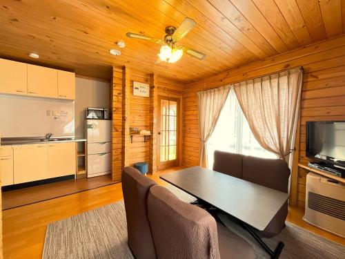 a kitchen and dining room with a table and chairs at Log Cottage Epoch in Hakuba