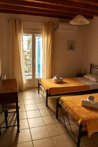 a bedroom with two beds and a window at Sunset Breeze Villa and Apartments in Tourlos