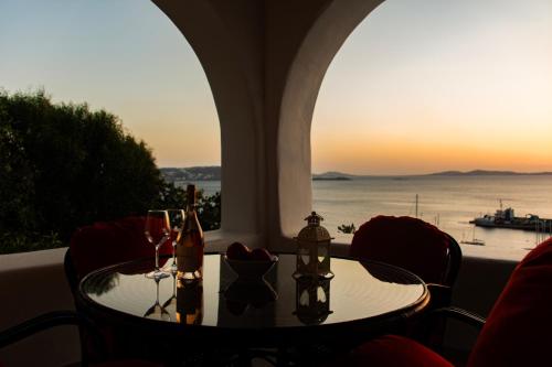 a table with wine glasses and a view of the ocean at Sunset Breeze Villa and Apartments in Tourlos