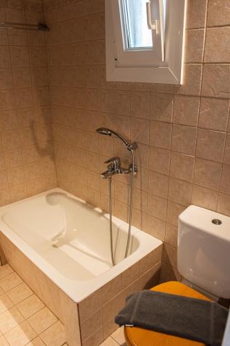 a bathroom with a bath tub and a toilet at Sunset Breeze Villa and Apartments in Tourlos