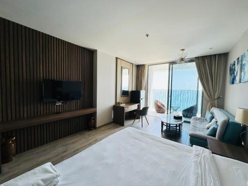 a hotel room with a bed and a television and a living room at Aqua De Hotel Panorama Nha Trang in Nha Trang