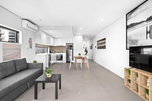 a living room with a couch and a table at New Modern 2BR 2baths Apt in Homebush Sleeps 6 in Sydney
