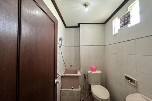 a bathroom with a toilet and a pink item on top of it at HOTEL WARTA SARI in Denpasar