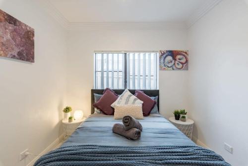 um urso de peluche sentado numa cama num quarto em Cozy Duplex Home 3 Bdrms 1 Bath Sleeps 6 em Glenfield