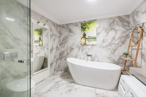 uma casa de banho com uma banheira branca e um lavatório. em Cozy Duplex Home 3 Bdrms 1 Bath Sleeps 6 em Glenfield