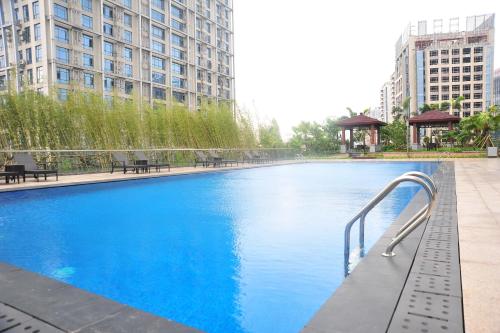 une grande piscine dans une ville avec des bâtiments dans l'établissement Dongguan Kande International Hotel-During the Canton Fair, guests can enjoy free shuttle buses to the Canton Fair exhibition hall, à Dongguan