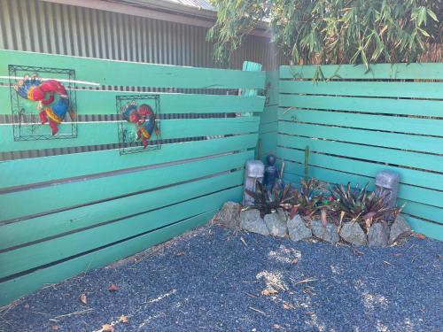 a blue fence with two parrots in mirrors on it at Heart of Witchcliffe in Margaret River Town