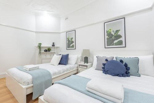 2 camas en una habitación blanca con almohadas azules en Homely 4 Bdrms House in Eastwood Sleeps 11, en Eastwood