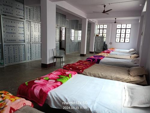 Cette chambre comprend plusieurs lits disposés dans une rangée. dans l'établissement Muzaffarpur Guest House, à Muzaffarpur