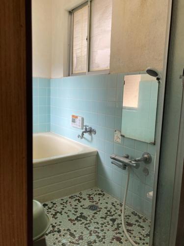 a blue bathroom with a tub and a sink at Veada in Kyoto