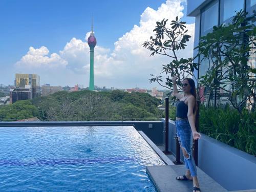 a woman standing on top of a building with a swimming pool at Peak of Colombo in Colombo