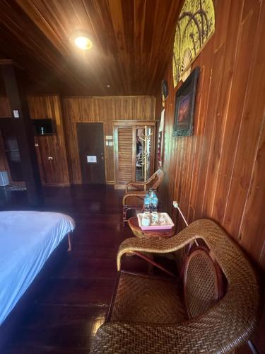 a room with a bed and two chairs and a table at KhounPhet GuusetHous Luangprabang in Luang Prabang
