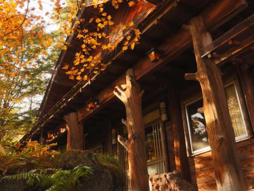 a log cabin with two trees outside of it at 雀の宿 やぐら in Matsumoto