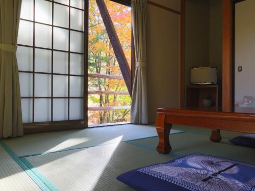 a room with a large window and a table at 雀の宿 やぐら in Matsumoto