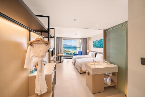 una camera d'albergo con letto e lavandino di The Oceanfront Apartment At Cam Ranh a Cam Ranh