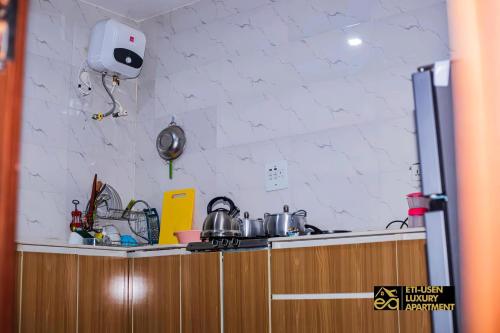 a kitchen with a counter with pots and pans at Eti-Usen Apartment in Uyo