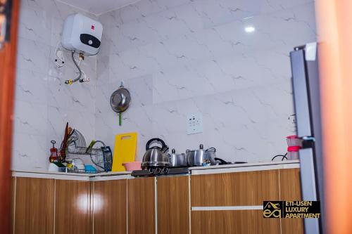 a kitchen with a counter with pots and pans at Eti-Usen Apartment in Uyo