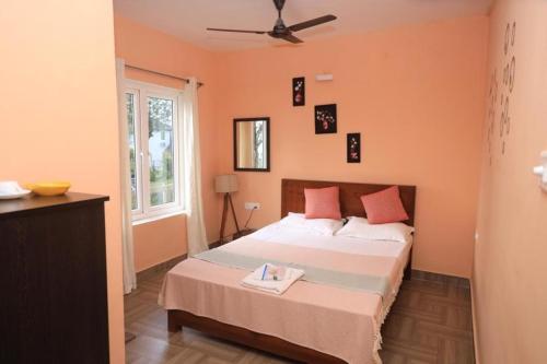a bedroom with a large bed with orange walls at Moonlight Chillers By LexStays in Yedapalli