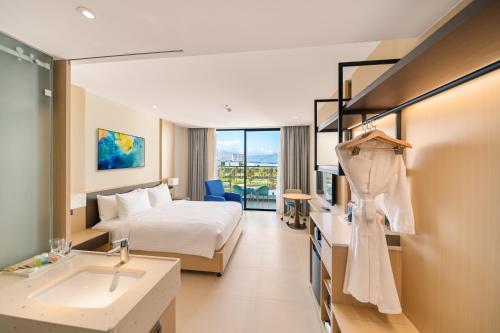 a hotel room with a bed and a sink at The Oceanfront Apartment At Cam Ranh in Cam Ranh