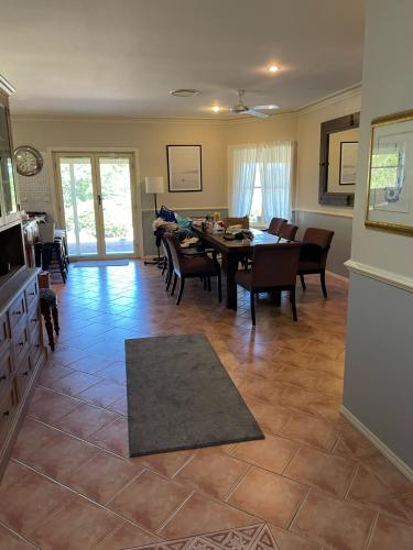 a kitchen and dining room with a table and chairs at Dulguigan Downs Farm House in Condong