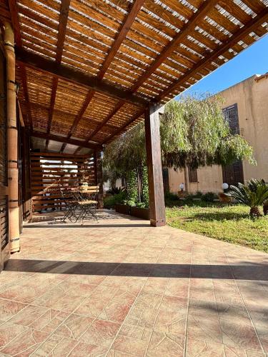 an outdoor patio with a wooden pergola at Casa Vacanze Albarìa in Birgi Vecchi