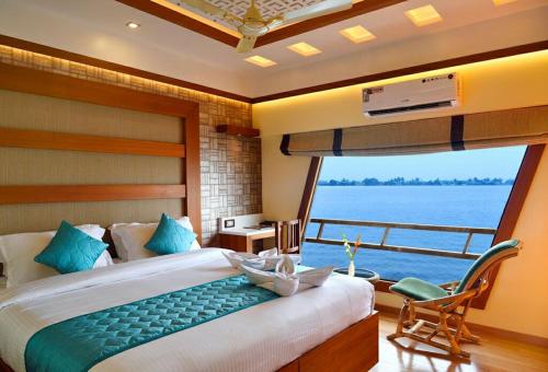 a bedroom with a large bed and a large window at Luxury Houseboat in Alleppey