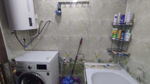 a bathroom with a washing machine and a washer at Уютная квартирка в центре Душанбе in Dushanbe