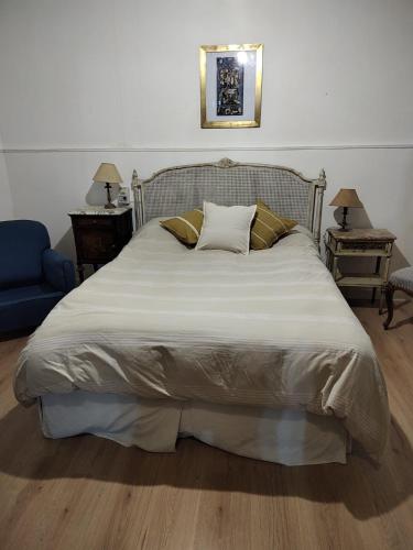 1 cama grande en un dormitorio con silla azul en Arenales Centro en Chascomús