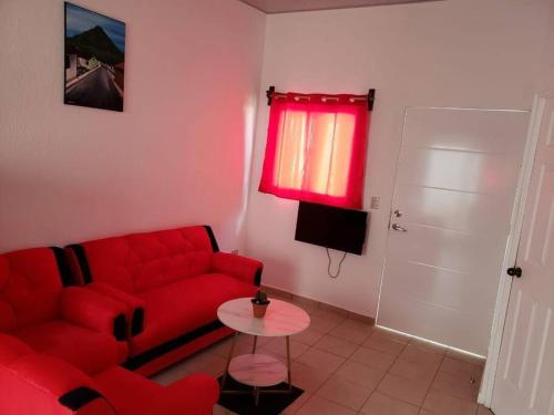 sala de estar con sofá rojo y mesa en Figueroa's House., en Santa Ana