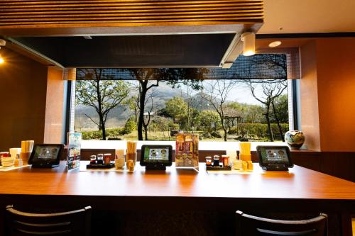 a restaurant with a table with four clocks on it at Yufuin Hotel Shuhokan in Yufuin