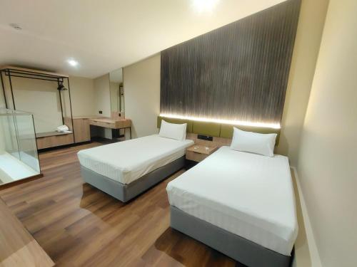 a hotel room with two beds and a mirror at I-VISTA HOTEL in Tawau