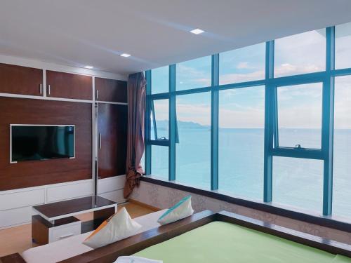 Habitación con ventana grande con vistas al océano. en Gold Beach Nha Trang Apartment, en Nha Trang